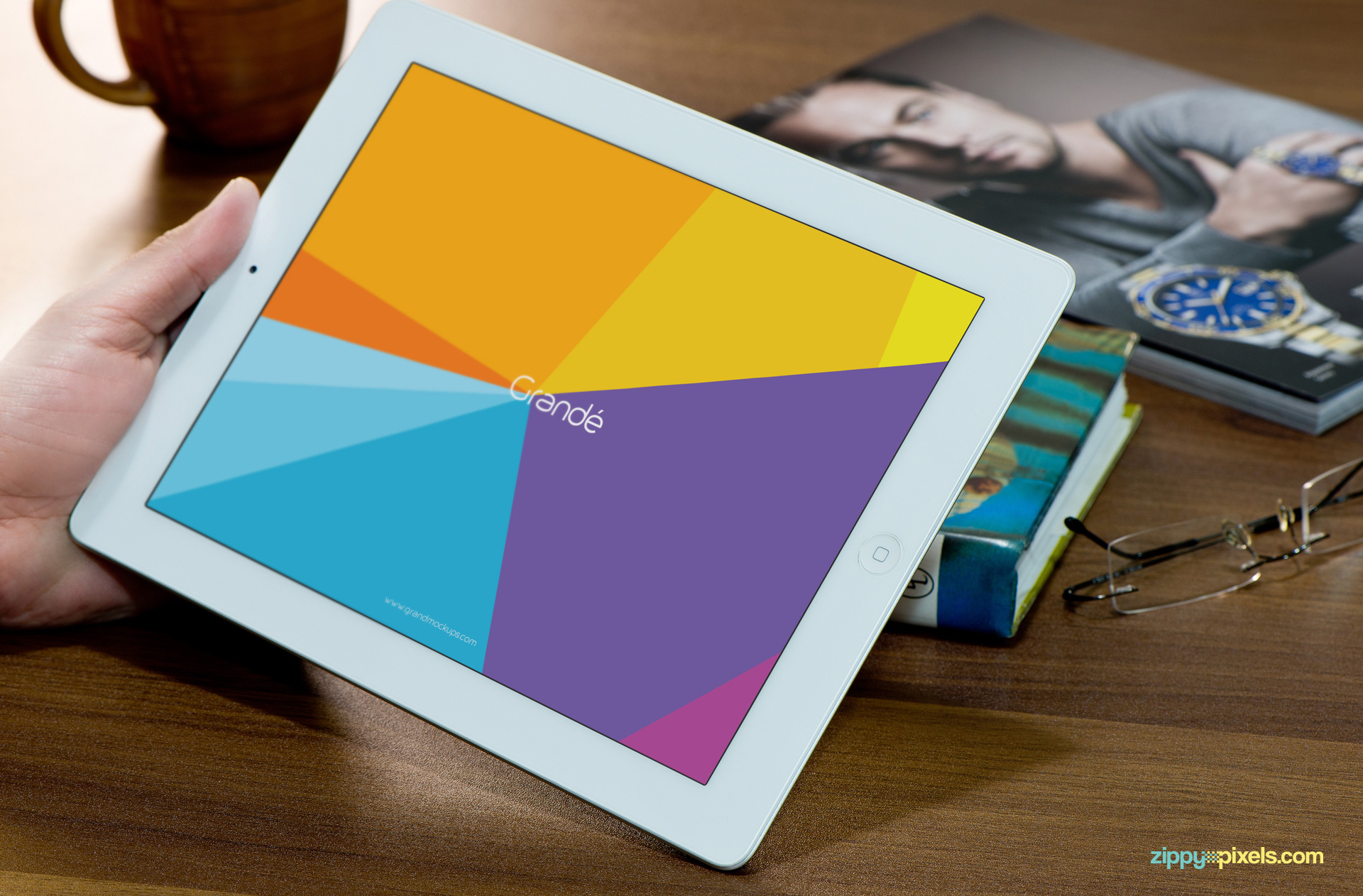 Free iPad Mockup of iPad held in hand with books in backgournd