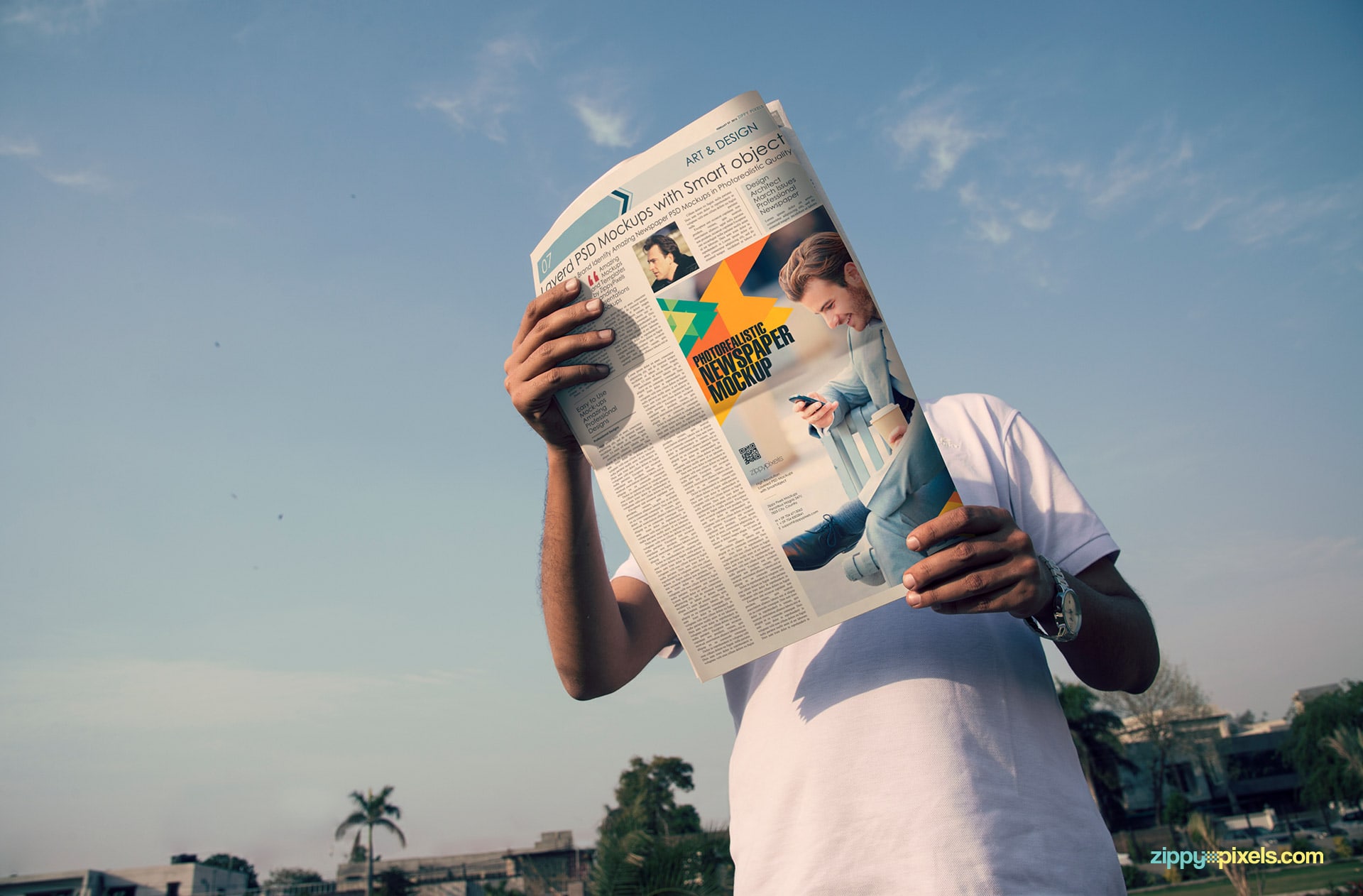 outdoor advertising mockup showing person holding newspaper from low angle with large ad and sky in background