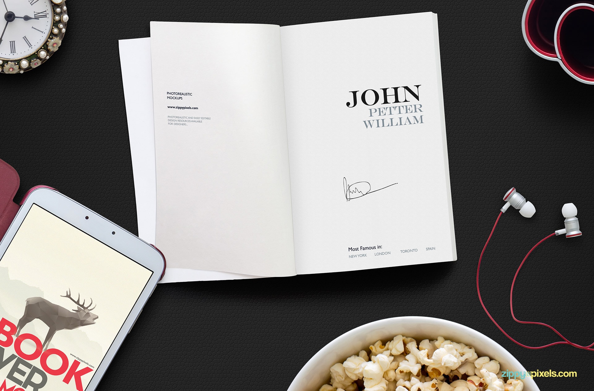 Opened book mockup psd showing a top down view of book title page, 10.1" tablet, bowl of pop corns, ear phones, pen holder & table clock